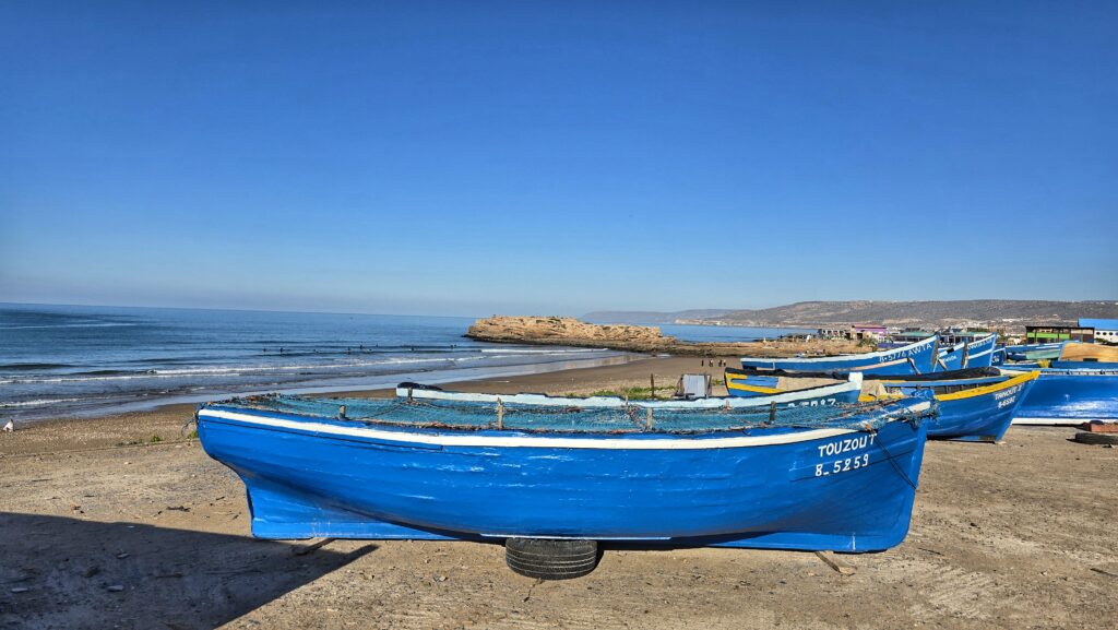 niebieskie łodzie nad brzegiem morza